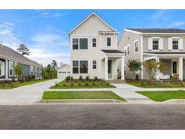 Charming two-story home with a well-manicured lawn, a detached garage, and a welcoming front porch at 198 Winding Branch Dr, Summerville, SC 29486