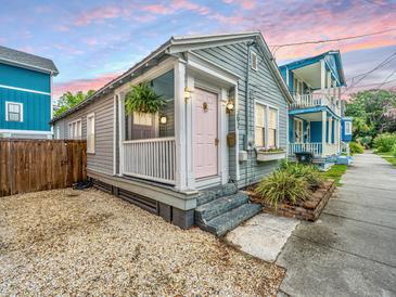 Charming single-story home showcasing a quaint porch, light-blue siding, and tidy landscaping at 202 Fishburne St, Charleston, SC 29403