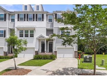 Charming townhome featuring an attached garage, manicured landscaping, and classic architectural details at 348 Spindlewood Way, Charleston, SC 29414