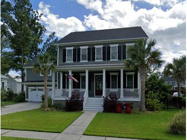 Charming two-story home featuring a cozy front porch, complemented by palm trees and lush green lawn at 3739 Goodwater St, Mount Pleasant, SC 29466