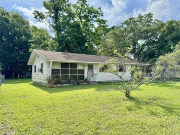 Quaint single-story home with a well-maintained lawn and mature trees providing shade at 524 Kell Pl, Charleston, SC 29412