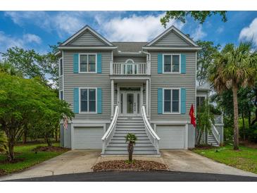 Charming two-story home with light grey siding, blue shutters, and a manicured front yard with palm tree at 5847 Back Bay Dr, Isle of Palms, SC 29451