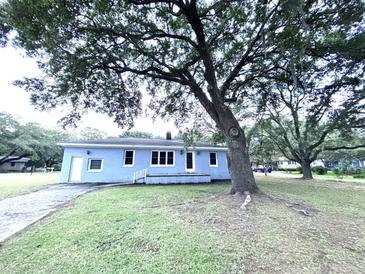 Charming single-story home with a well-maintained yard, mature trees, and a welcoming front porch at 1871 Grimball Rd, Charleston, SC 29412