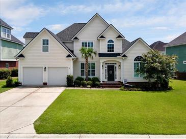 Beautifully landscaped two-story home featuring a two-car garage and manicured lawn at 1003 Jervey Point Rd, Wando, SC 29492
