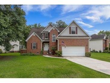 Charming two-story brick home featuring an attached two car garage and a well-manicured lawn at 116 Holbrook Ln, Goose Creek, SC 29445