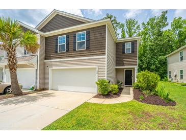 A well-maintained townhouse showcasing a two-car garage, manicured lawn, and appealing exterior finishes at 124 Bright Meadow Rd, Summerville, SC 29483