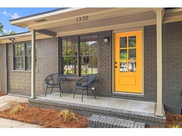 Inviting home exterior with a bright yellow door and charming front porch seating at 1320 Bresee St, Charleston, SC 29412