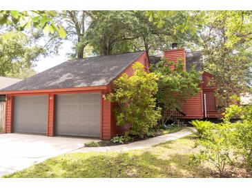 Charming exterior of red home featuring an attached two-car garage and well-maintained landscaping at 152 Mansfield Blvd, Charleston, SC 29418