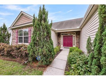 Charming home featuring a red front door, stone accents, manicured landscaping, and lovely red shutters at 193 Cypress Forest Dr, Moncks Corner, SC 29461