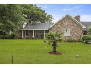Charming brick home with a well-manicured lawn, mature trees, and a cozy front porch at 4735 W Park Pl, North Charleston, SC 29405