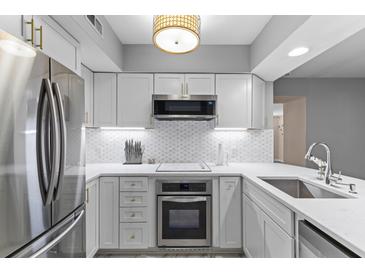 Bright, modern kitchen features white cabinetry, stainless steel appliances and white marble countertops at 55 Ashley Ave # 6, Charleston, SC 29401