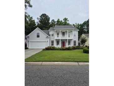Charming two-story home with well-manicured lawn and inviting red front door at 605 Pointe Of Oaks Rd, Summerville, SC 29485