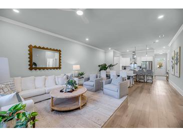Bright open-concept living room with comfortable seating and stylish decor for modern relaxation and entertaining at 7416 Indigo Palms Way, Johns Island, SC 29455