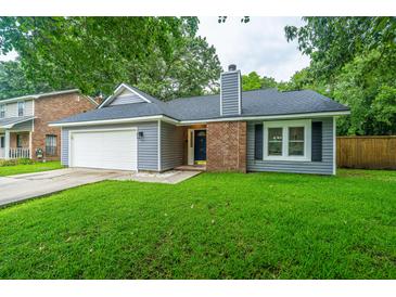 Charming single-story home featuring a well-manicured lawn, attached garage and brick chimney at 105 Glebe Rd, Summerville, SC 29485