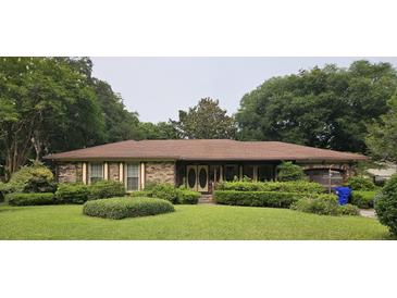 Charming brick ranch-style home with lush landscaping and a well-maintained lawn at 1350 Winifred St, Mount Pleasant, SC 29464