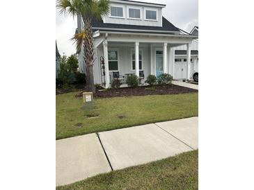 Charming home with a manicured lawn, inviting porch, and a vibrant blue front door at 1515 Pogonia St # 2, Mount Pleasant, SC 29466