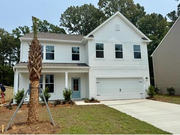Charming two-story home with white siding, an attached two-car garage, and a neatly manicured lawn at 2018 Quiet Ibis Rd, Hanahan, SC 29410