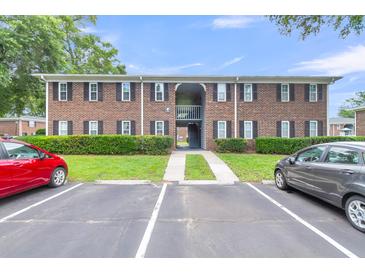 Brick apartment building exterior with parking and landscaping under a blue sky at 21 Rivers Point Row # 17G, Charleston, SC 29412