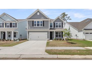 Charming two-story home with gray siding, a two-car garage, and a well-maintained front yard at 327 Hillman Trl Dr, Moncks Corner, SC 29461