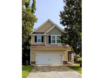 Charming two-story home with a two-car garage, neutral siding, and lush green trees, offering a welcoming curb appeal at 3706 Blackjack Rd, Ladson, SC 29456