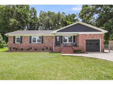 Charming brick home with a well-manicured lawn, inviting entrance, and attached garage at 6305 Lucille Dr, North Charleston, SC 29406