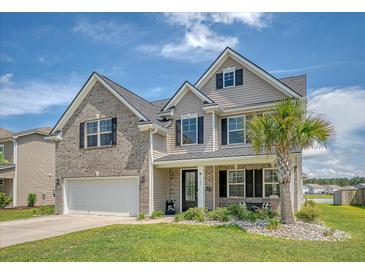Charming two-story home with a brick and siding facade, a manicured lawn and an attached two-car garage at 143 Airy Dr, Summerville, SC 29486