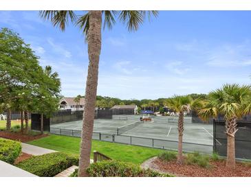 Scenic view of well-maintained tennis courts surrounded by lush greenery and palm trees, offering a vibrant recreational setting at 1627 Live Oak Park, Seabrook Island, SC 29455