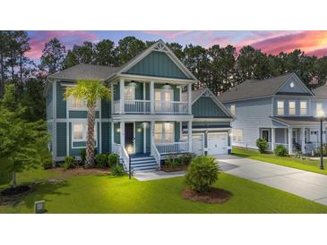 Inviting two-story home with a charming porch, lush lawn, and a well-manicured landscape at 183 Calm Water Way, Summerville, SC 29486
