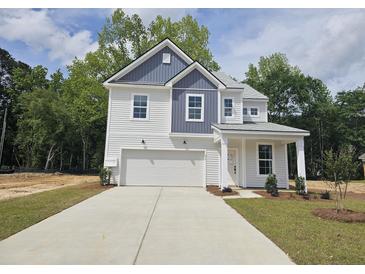 New two-story home with a two-car garage and a manicured front yard at 410 Cadbury Loop, Summerville, SC 29486