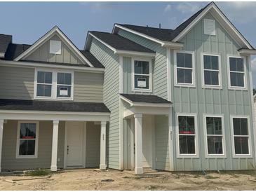 Newly built townhomes boast light green siding, black roof, and white trim, creating a modern farmhouse appeal at 823 Alma Square Dr, Moncks Corner, SC 29461