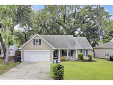 Charming single-story home with a manicured lawn, attached garage, and mature trees at 8612 Hickory Creek Ln, North Charleston, SC 29420