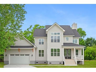 New construction with gray siding, black roof, attached garage, and covered front porch at 1076 Williams Rd, Charleston, SC 29412