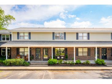 Inviting two-story townhome with a brick facade, cozy porch, and manicured landscaping at 1166 Julian Clark Rd, Charleston, SC 29412