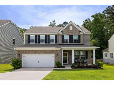 Charming two-story home with a combination brick and vinyl exterior and a well-manicured front lawn at 1825 Crossbill Trl, Hanahan, SC 29410