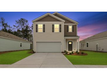 Charming two-story home featuring a two-car garage and well-manicured lawn at 2242 Macallan Blvd, Ravenel, SC 29470