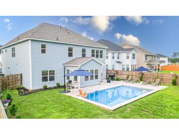Backyard view of pool with patio furniture and well-maintained lawn at 256 Fiddleback Dr, Summerville, SC 29486