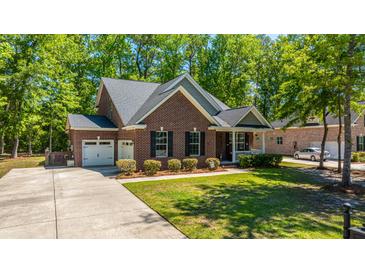 Charming brick home with a well-manicured lawn, attached garage, and a cozy front porch, nestled among mature trees at 5442 Clearview Dr, North Charleston, SC 29420