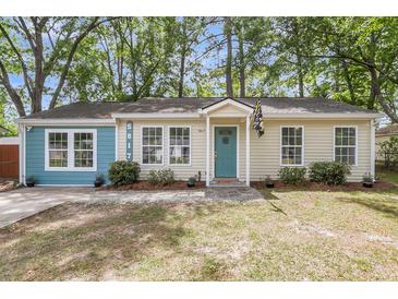 Charming single-story home with a light blue door, light yellow siding, and a well-maintained front yard at 5817 Canterbury Dr, Hanahan, SC 29410
