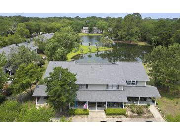 An aerial view of a townhome with a gray roof overlooking a scenic pond and lush greenery at 925 Dills Bluff Rd # 34, Charleston, SC 29412