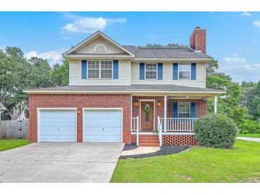 Charming two-story home with a brick facade, inviting front porch, a two-car garage and well-maintained lawn at 100 Cicero Ct, Goose Creek, SC 29445