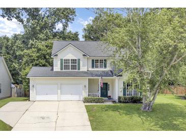 Charming two-story home with a two-car garage, a well-manicured lawn, and beautiful trees providing shade at 103 Trimley Ct, Goose Creek, SC 29445