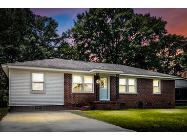 Charming brick ranch-style home with a well-manicured lawn and mature trees creating a serene atmosphere at 116 Lyle Rd, Goose Creek, SC 29445
