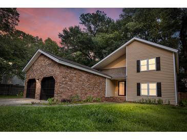 Inviting two-story home with brick accents and a spacious two-car garage under a colorful dusk sky at 119 Scottswood Dr, North Charleston, SC 29418