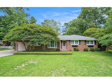 Charming brick home with a lush green lawn and mature landscaping creating inviting curb appeal at 1833 St Julian Dr, Charleston, SC 29407