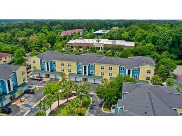 Bright apartment complex featuring blue and yellow exterior with tree lined parking and manicured landscaping at 2000 Belle Isle Ave # 204, Mount Pleasant, SC 29464
