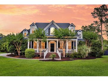 Charming two-story home features a manicured lawn, and a welcoming front porch at 2720 Oak Manor Dr, Mount Pleasant, SC 29466