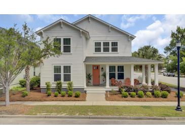 Charming two-story home with a welcoming front porch, manicured landscaping, and a vibrant orange front door at 351 Gnarly Oak Ln, Summerville, SC 29485