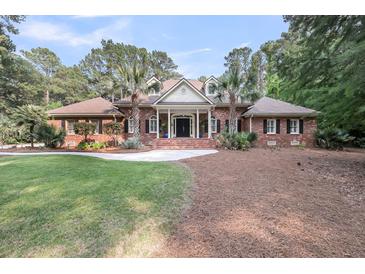 Beautiful brick home with a symmetrical facade, manicured lawn, and mature landscaping at 3555 Colonel Vanderhorst Cir, Mount Pleasant, SC 29466