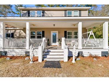 Inviting two-story home featuring a spacious covered front porch with white columns and porch swing at 62 Wexford Way, Walterboro, SC 29488