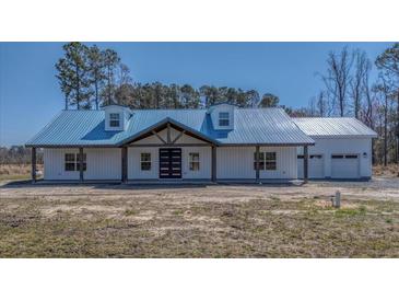 Beautiful new construction home with a blue metal roof and white siding at 709 Oakridge View Trl, Ridgeville, SC 29472